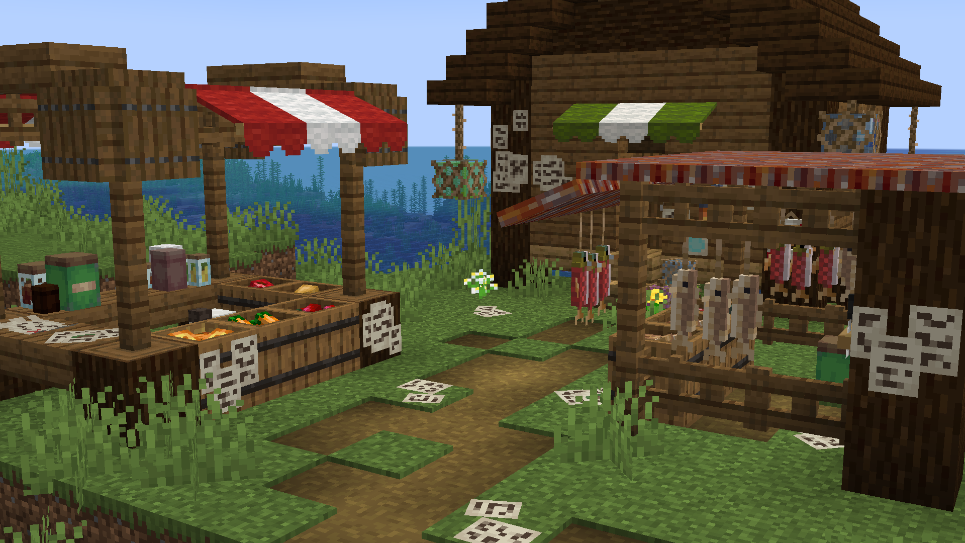 Screenshot of a minecraft market, with 2 stalls in front of a sea-side house. Modded blocks such as papers and jars litter the floor and stalls.