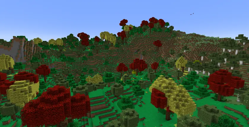 an overhead view of a calm forest with bright green grass and yellow and red trees